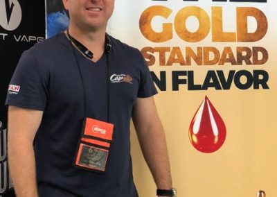 Ryan Silva with stand banner that says the gold standard in flavor